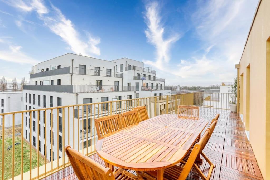 d'une terrasse avec une table et des chaises en bois sur un balcon. dans l'établissement Kabala - ParisNord Villepinte CDG StadedeFrance, à Bondy