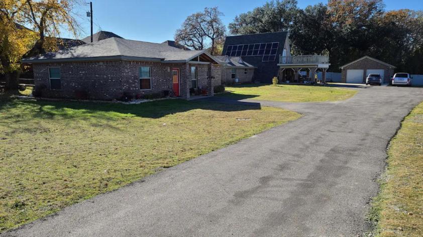 an empty road in front of a brick house at Adorable 2-bedroom guesthouse with patio in Weatherford