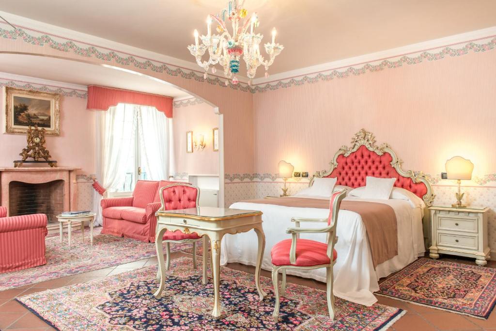 a bedroom with a bed and a fireplace at Duchessa Isabella Hotel & SPA in Ferrara