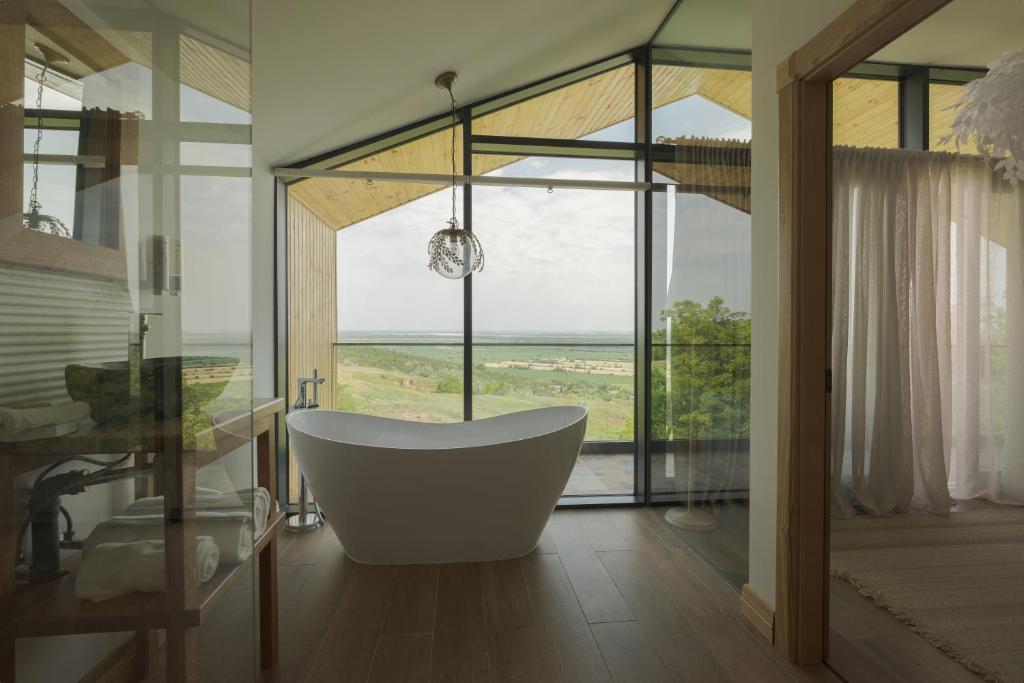 een badkamer met een bad en een groot raam bij Zen Resort & SPA in Purcari