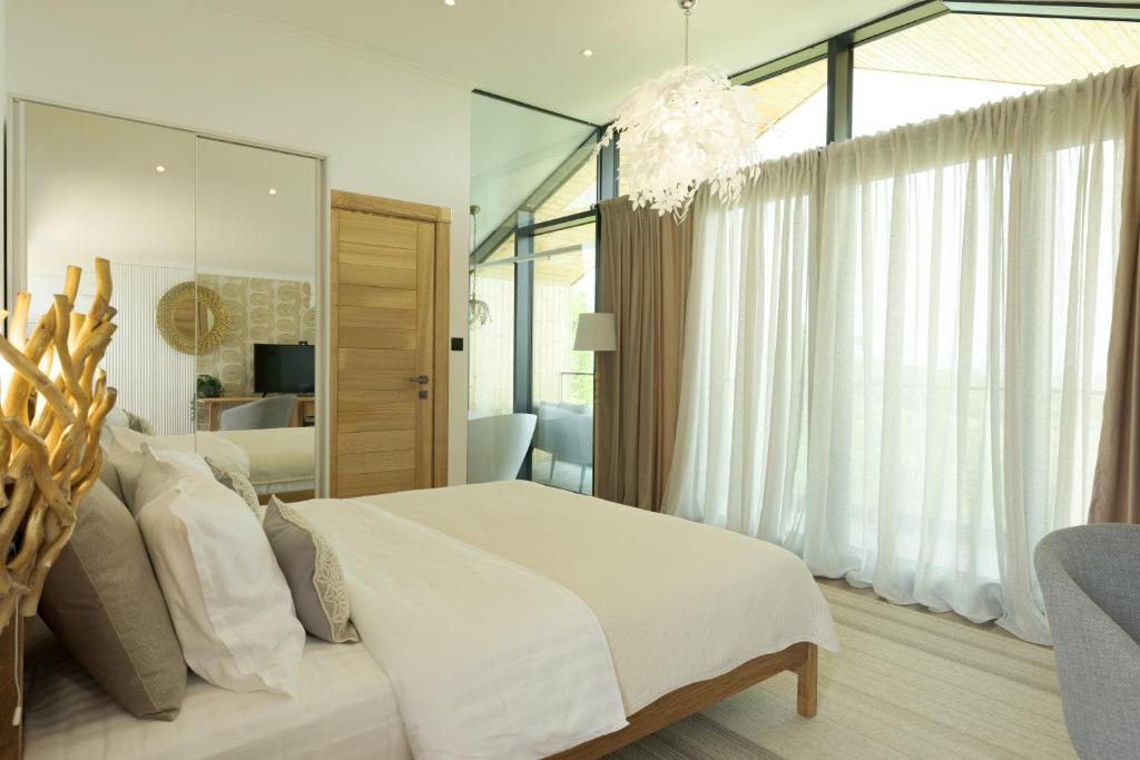 een slaapkamer met een wit bed en een groot raam bij Zen Resort & SPA in Purcari