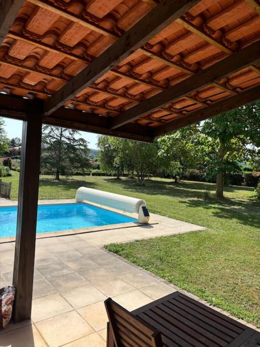 - une piscine dans une arrière-cour avec un toit en bois dans l'établissement La Vie en Rose, à Léran