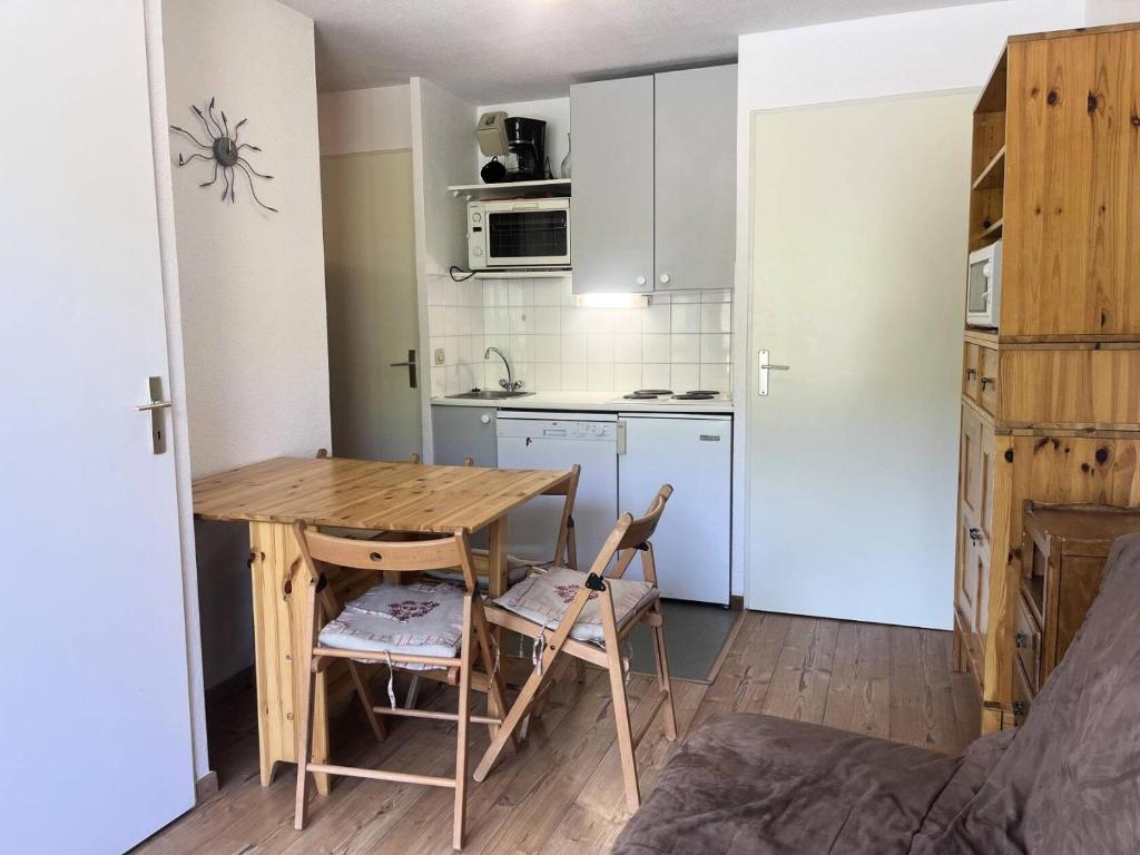 une petite cuisine avec une table et des chaises dans une pièce dans l'établissement Résidence Les Drus - Résidence LES DRUS N°202 MAE-4691, à La Plagne Tarentaise