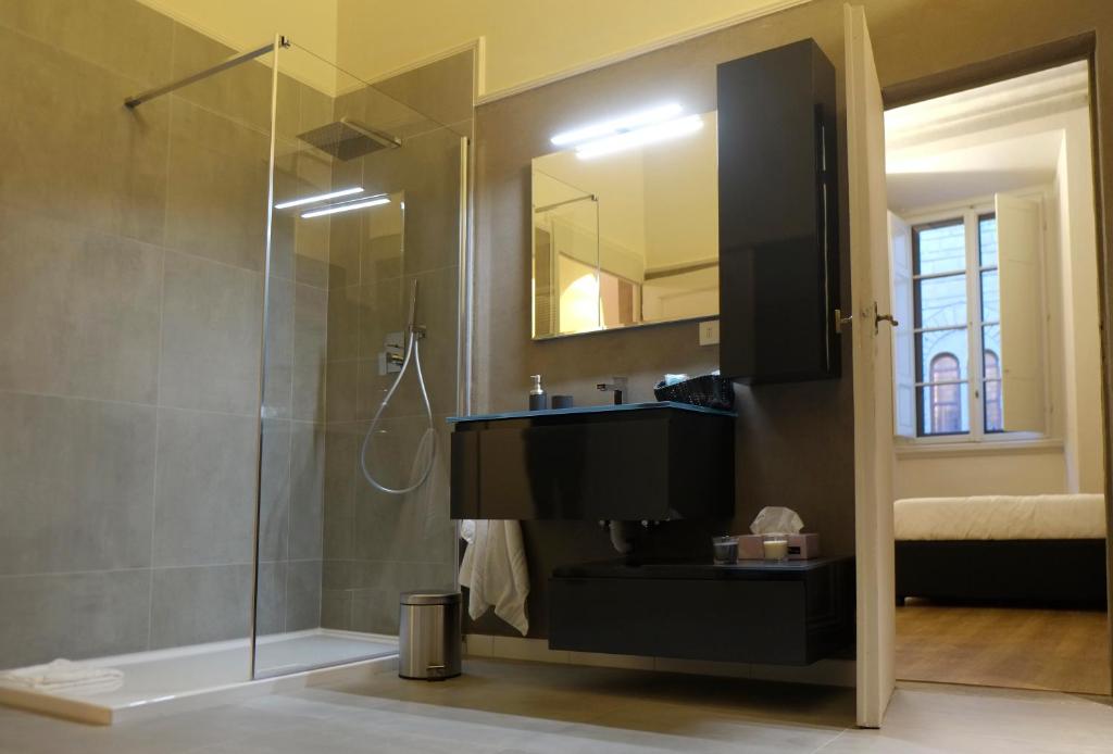 bagno con lavandino e doccia in vetro di Strozzi Luxury Apartment a Firenze