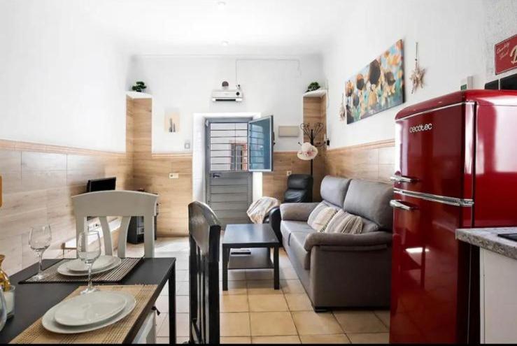 a living room with a couch and a red refrigerator at Casa Adela in Barbate