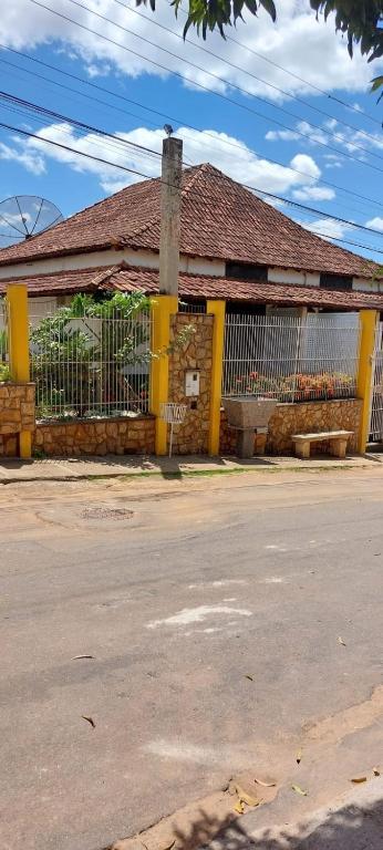 an old building with a fence in front of a street at Pousada Colonial in Cachoeiro de Itapemirim