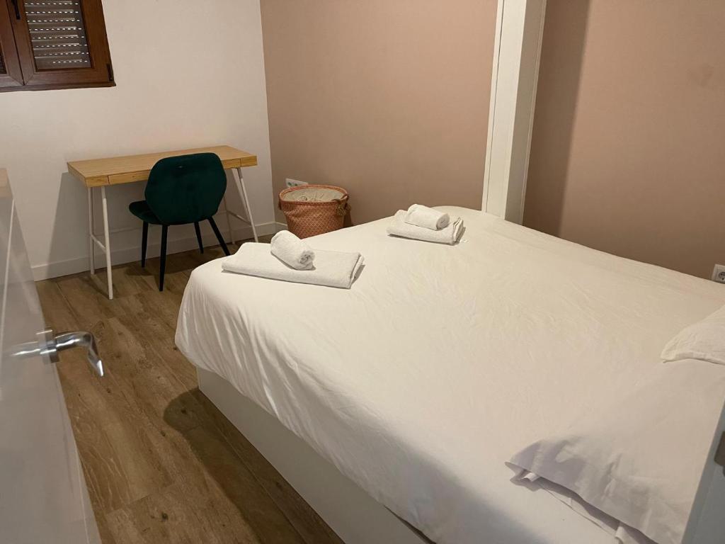 a bedroom with a white bed with a desk and a chair at Apartamento Robledo de Chavela Plaza 1A in Robledo de Chavela