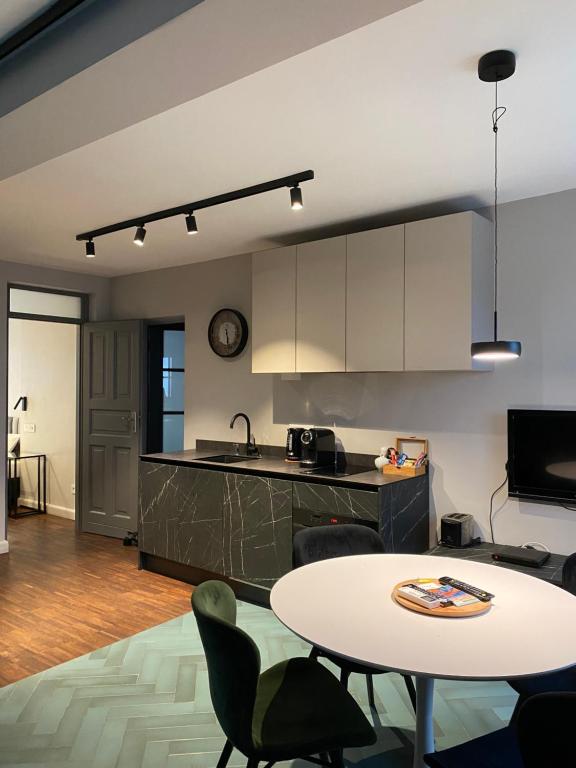 a kitchen and living room with a table and chairs at Arte-locum Apartamenty przy Rynku in Wrocław