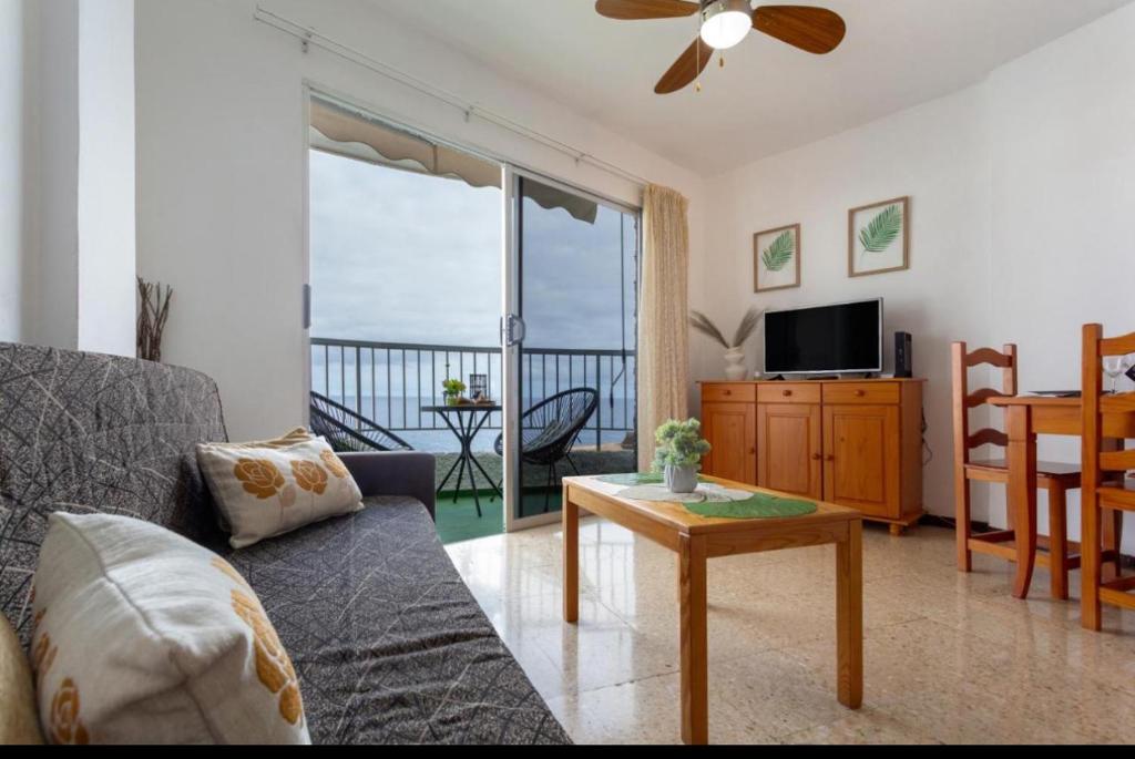VISTA AL MAR في إيكود ذي لوس فينوس: غرفة معيشة مع أريكة وطاولة