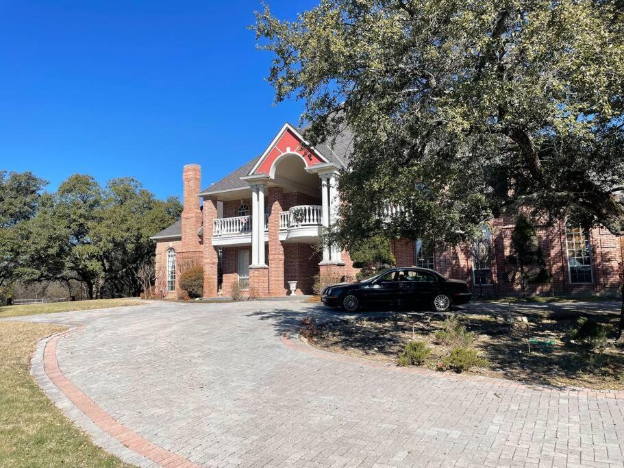 a black car parked in front of a brick house at Stunning Country Mansion Estate in SW Fort Worth in Benbrook