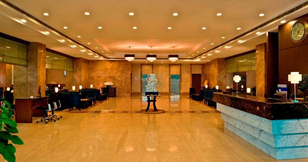 a lobby of a hotel with a bar in the middle at Red Fox Hotel Bhiwadi in Bhiwadi