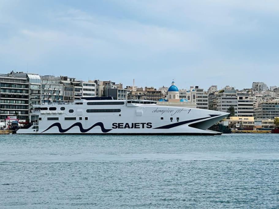 a large boat in the water with buildings in the background at Grey Suite at Piraeus Port in Piraeus