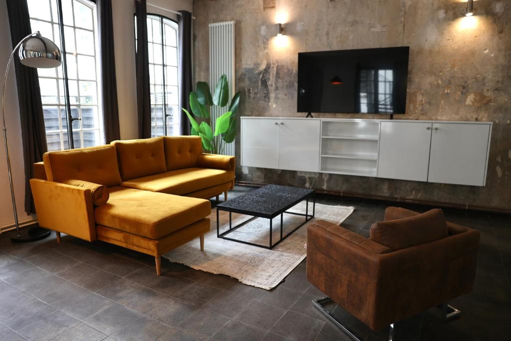 Hotel Loft Apartment Hamburg Hauptbahnhof, a living room with a couch and a tv at Loft Apartment Hamburg Hauptbahnhof in Hamburg