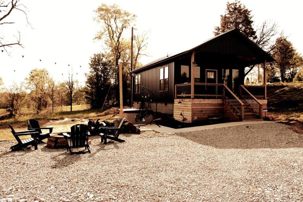 a cabin with a table and chairs in front of it at Bourbon Barrel Cottages #5 on Ky Bourbon Trail in Lawrenceburg
