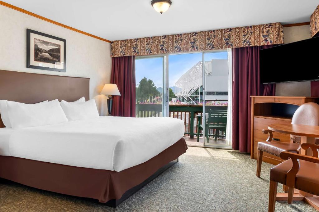 a hotel room with a bed and a large window at Best Western Adirondack Inn in Lake Placid