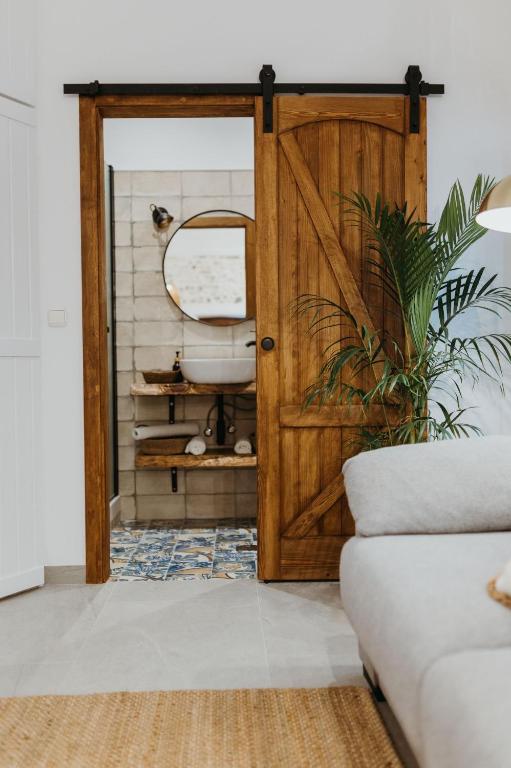 a bathroom with a wooden door and a sink at La Casita in Almuñécar