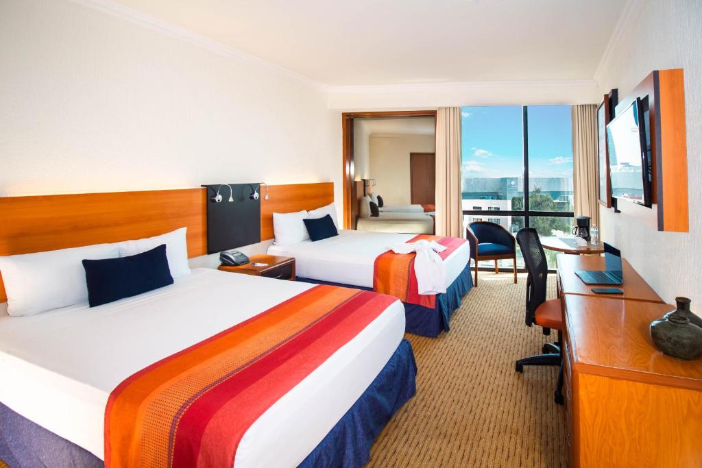 Postel nebo postele na pokoji v ubytování Hotel Guadalajara Plaza Expo