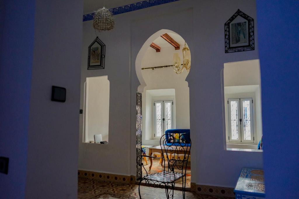 sala de estar con arco y comedor en Authentic Dual Terrace house, en Chefchaouen