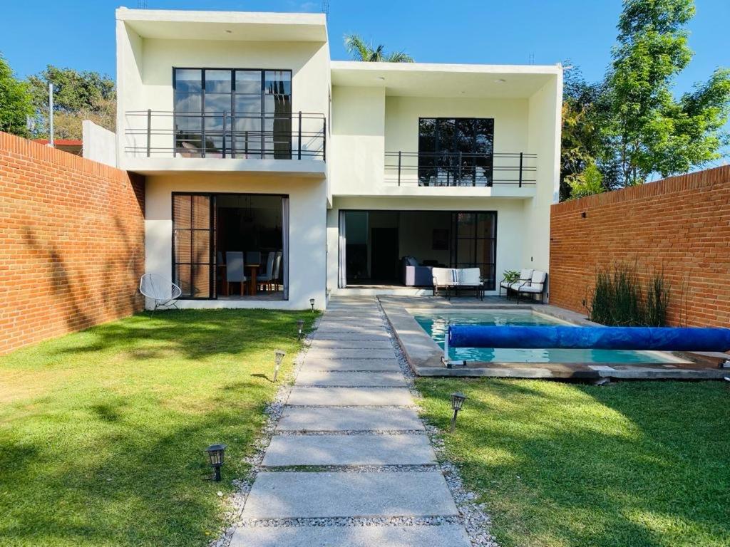 a house with a blue couch in the yard at Industrialhaus Alberca privada y climatizada in Ahuatepec
