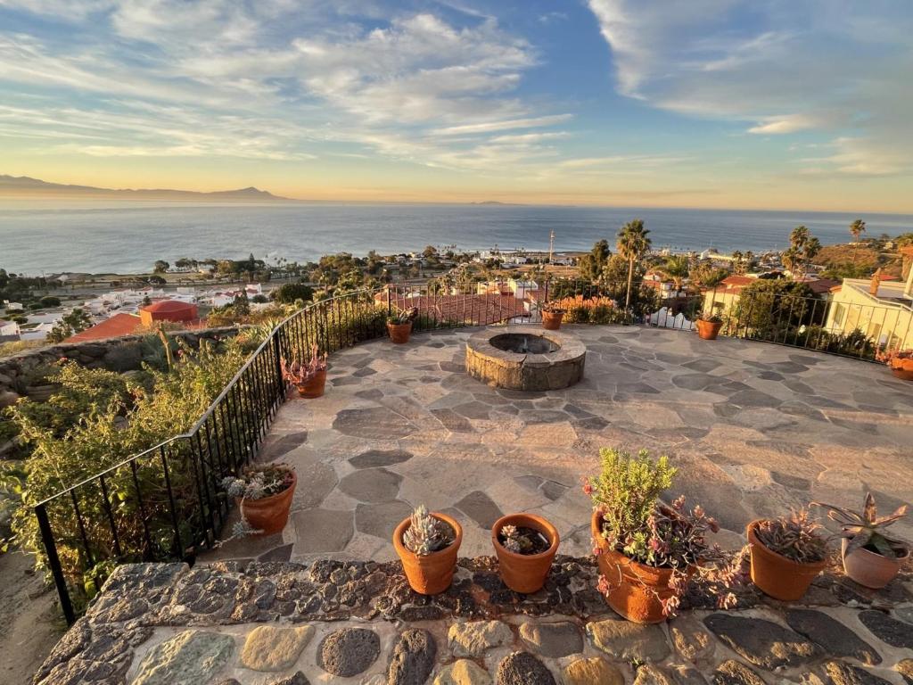 a patio with a fire pit and potted plants at Su Casa in Ensenada
