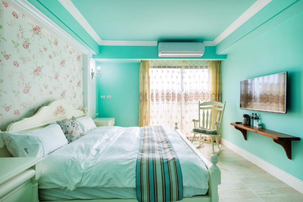 a blue bedroom with a bed and a window at Ediman Bed &amp; Breakfast in Hualien City
