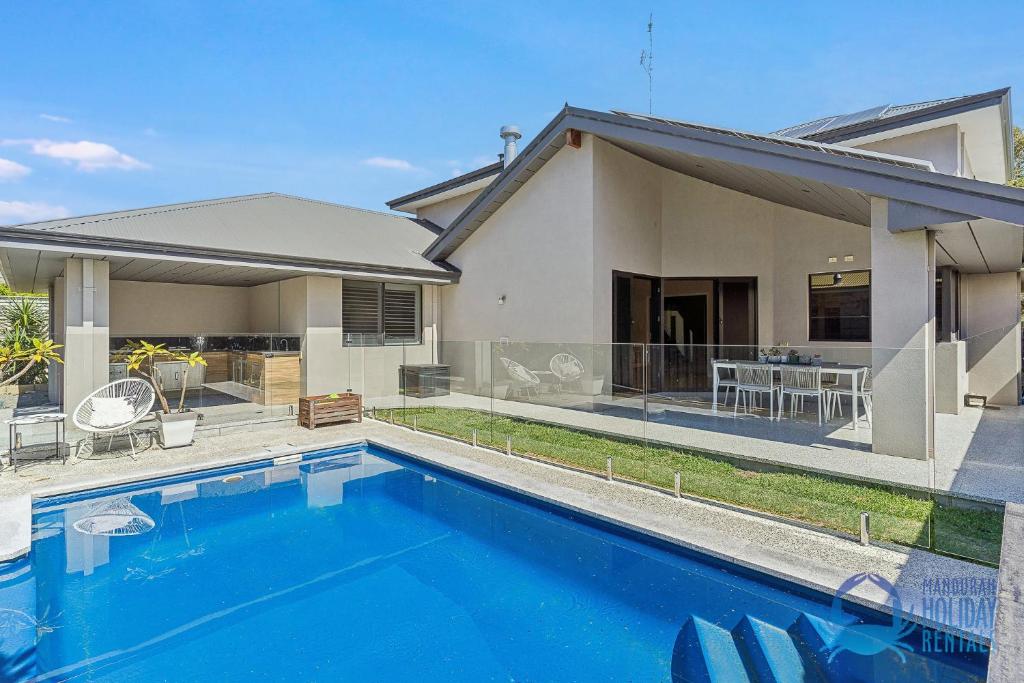 a swimming pool in front of a house at Soldiers Cove Luxury Retreat in Mandurah