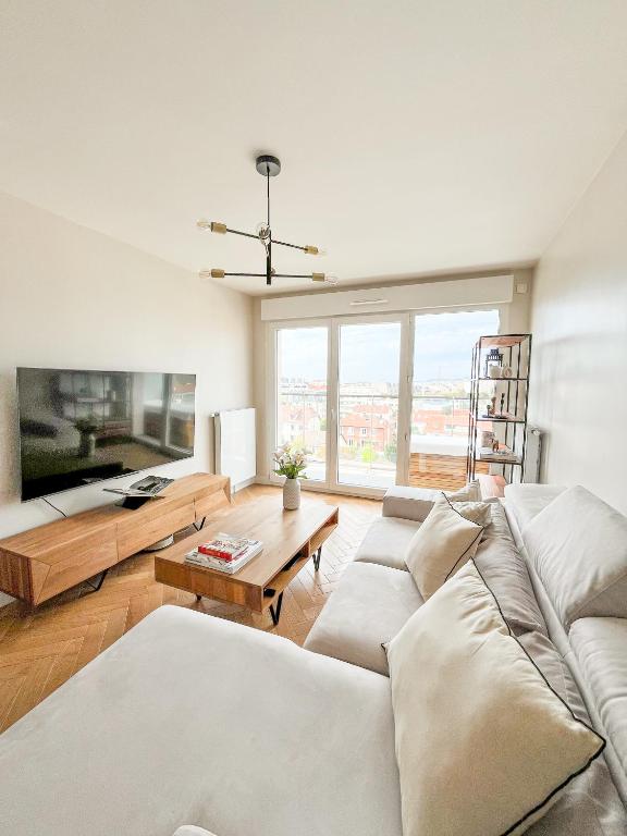 un salon avec un canapé et une grande fenêtre dans l'établissement 10 Minutes From Paris - Stunning Views - Scandi Zen Paris, à La Garenne-Colombes
