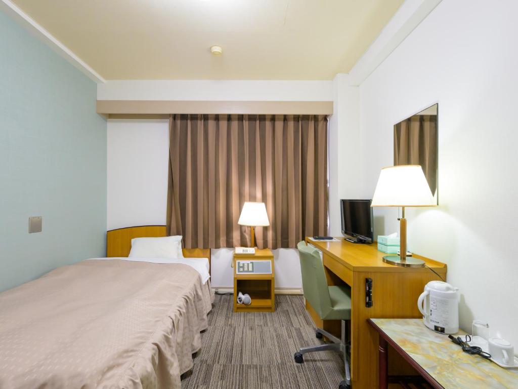 Postel nebo postele na pokoji v ubytování Hisai Green Hotel
