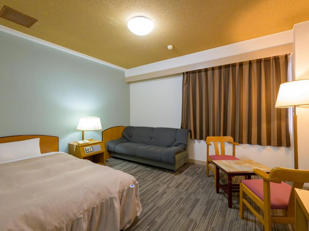 Postel nebo postele na pokoji v ubytování Hisai Green Hotel