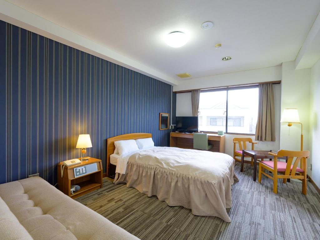 Postel nebo postele na pokoji v ubytování Hisai Green Hotel