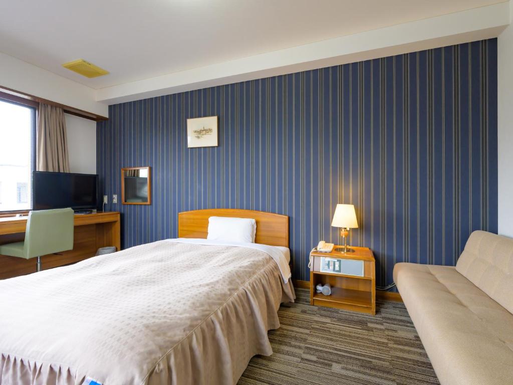 Postel nebo postele na pokoji v ubytování Hisai Green Hotel