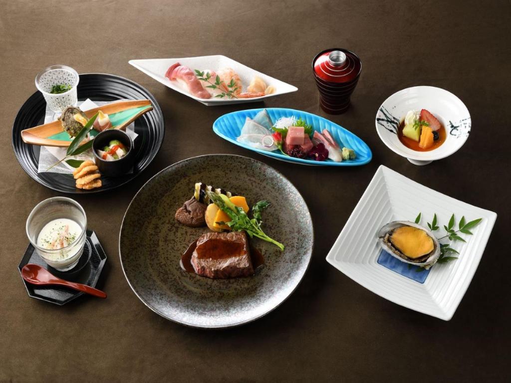 a wooden table with plates of food on it at Shinjuku Prince Hotel in Tokyo