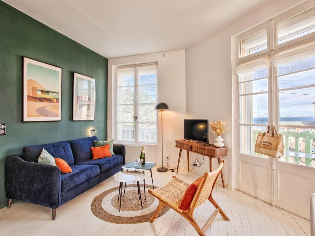 un salon avec un canapé bleu et une table dans l'établissement Superbe appartement rénové à Cabourg, face à la mer pour 2 - FR-1-788-33, à Cabourg
