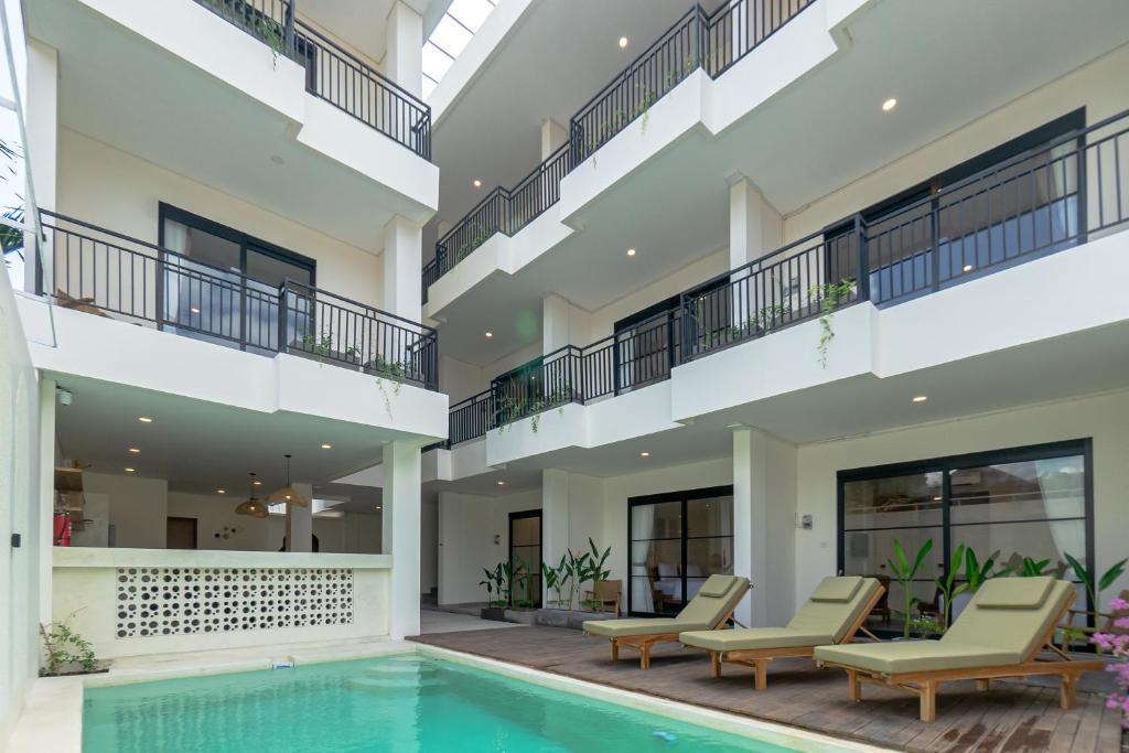 Un edificio de apartamentos con piscina y dos balcones. en Kelaya Guesthouse, en Sanur