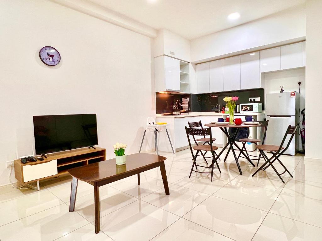 a kitchen and living room with a television and a table at KUROMI Theme Suite for Families- 3min drive Legoland & EcoBotanic in Nusajaya