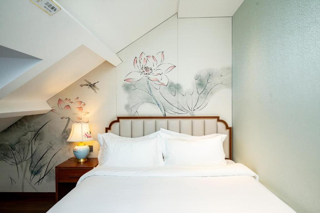 een slaapkamer met een bed met een muurschildering van bloemen aan de muur bij Pierr Palace Hotel (Beijing Nanluo Guxiang) in Beijing