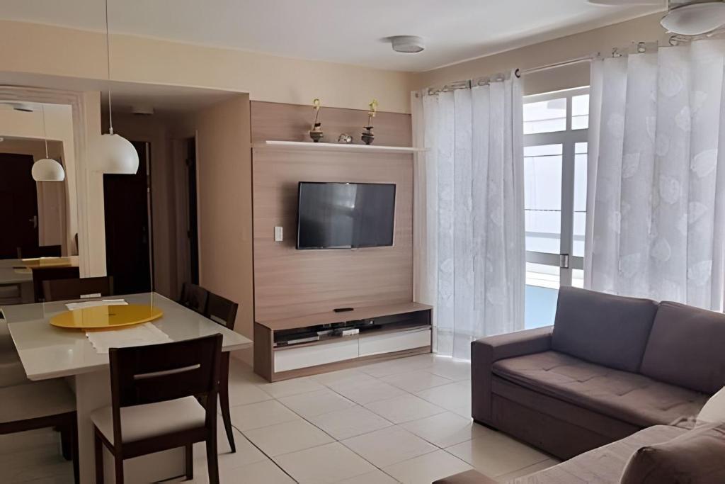 a living room with a couch and a table and a tv at Apto perfeito em Arraial do Cabo - Prainha in Arraial do Cabo