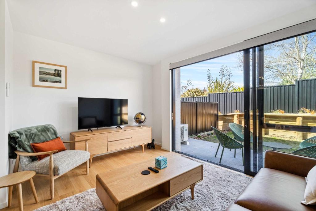 a living room with a tv and a couch and a table at Mt Roy Delight in Wanaka