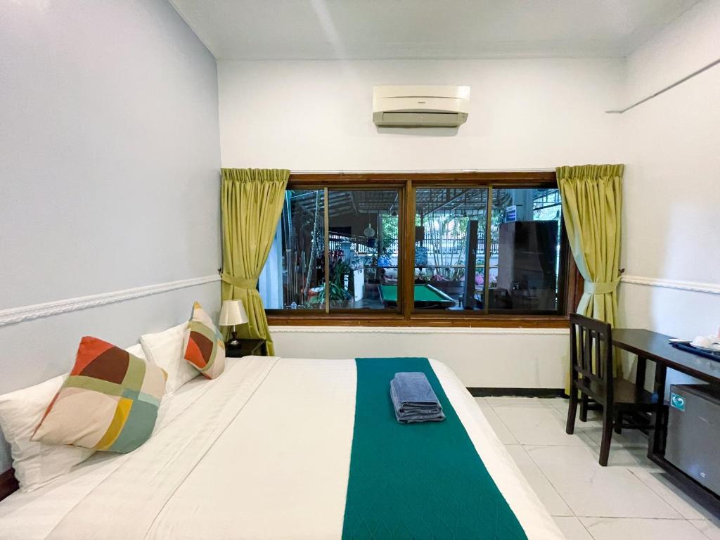 a bedroom with a bed and a desk and a window at Birdcage Boutique in Phnom Penh