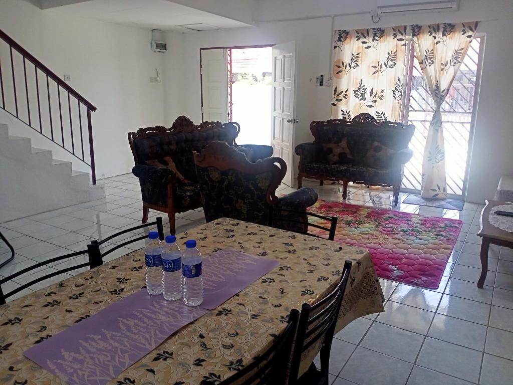 a dining room with a table with bottles of water on it at Homestay Atikah Bahau in Bahau