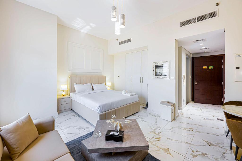 a hotel room with a bed and a couch at Charming Studio with Dubailand Charm in Dubai