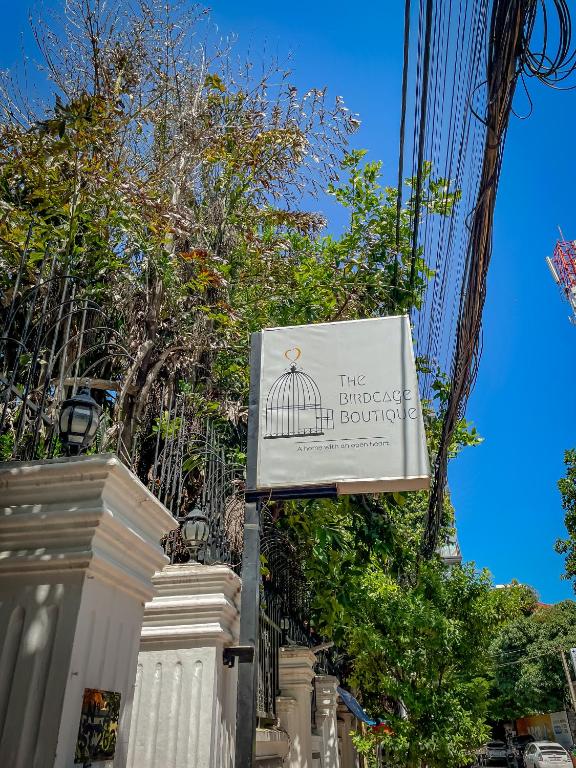 a sign for a building with a bird in a cage at Birdcage Boutique in Phnom Penh