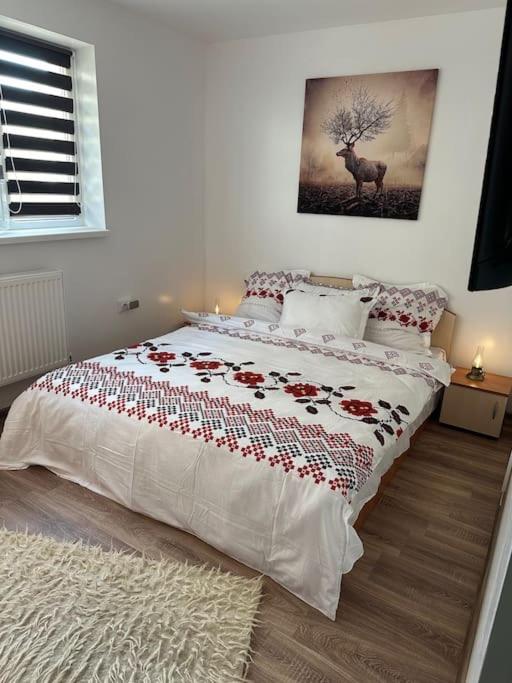 una camera da letto con un grande letto con rose sopra di Chic Urban Retreat a Drîmbar