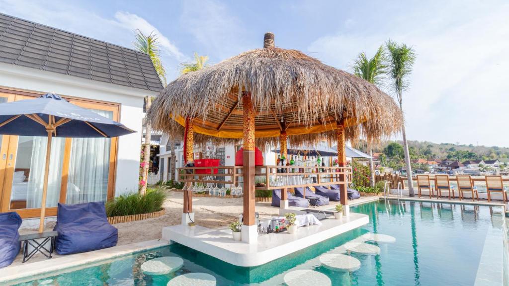 a resort with a swimming pool and a thatch umbrella at Segara Seaside Resort in Nusa Lembongan