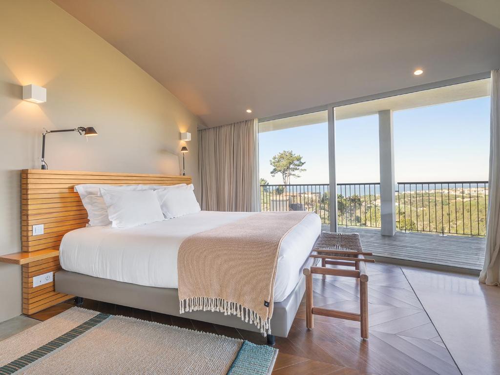 a bedroom with a large bed and a large window at Immerso Hotel, a Member of Design Hotels in Ericeira