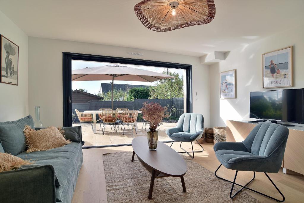 a living room with a couch and chairs and a table at Cancale à la plage - Maison avec terrasse pour 6 in Cancale