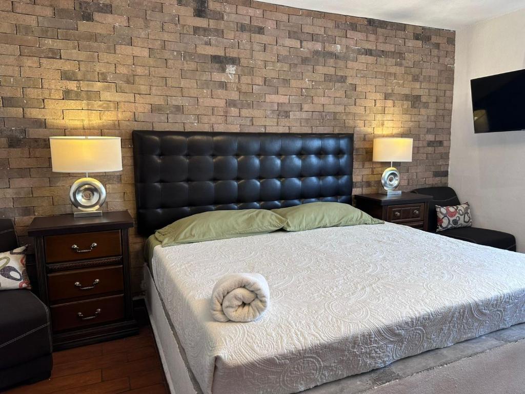 a bedroom with a large bed with a black headboard at Suites Apodaca in Monterrey