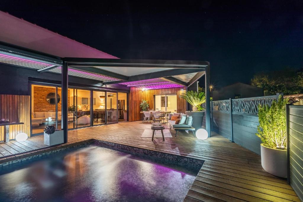une maison avec une piscine sur une terrasse la nuit dans l'établissement Villa Genêts, à Montaud