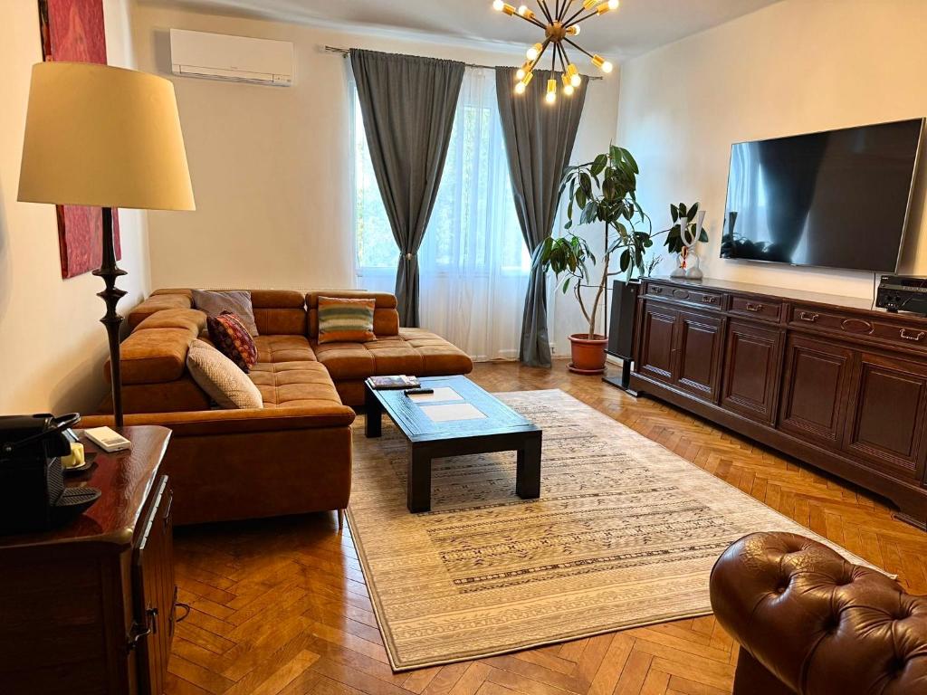 a living room with a couch and a flat screen tv at Dream Home Modern 2BR Apartment Turda Free Parking Near Salina Turda in Turda
