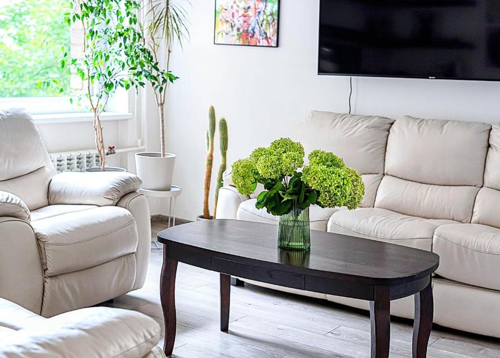 a living room with a table with a vase on it at Algirdo Apartments, Self Check-in, Free Private Parking in Vilnius